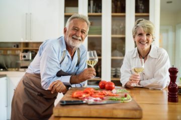 man and woman in kitchen enjoying wine