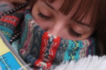 woman with scarf around face sleeping